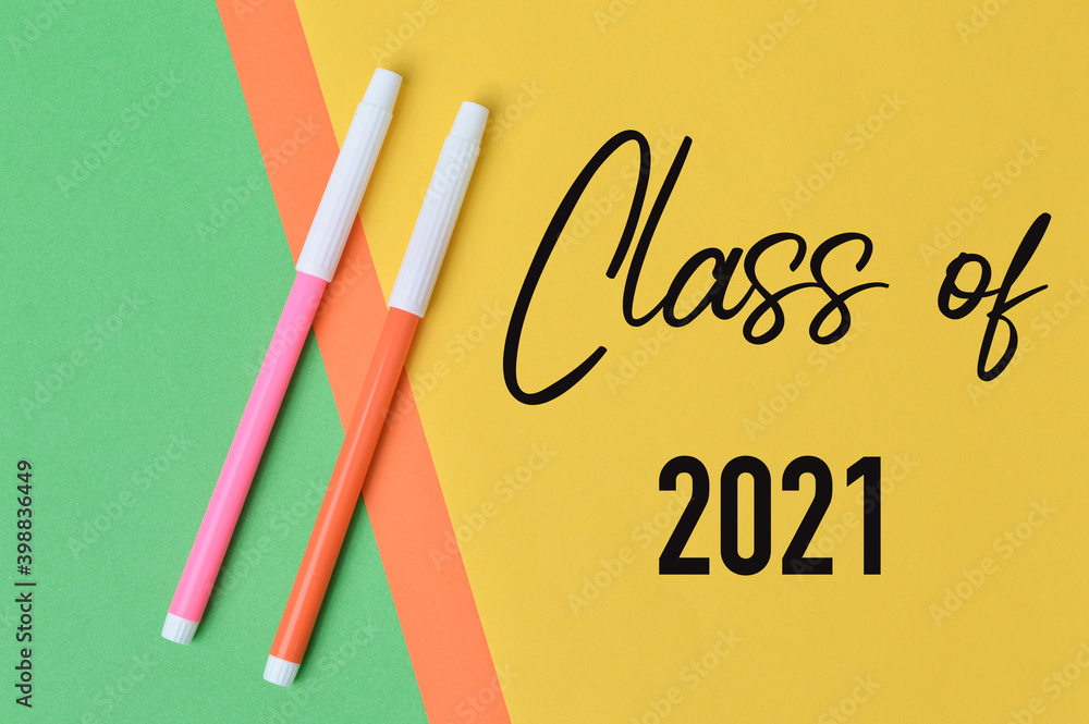 Fototapete top view of pen colors over colorful papers written with text class of 2021. education concept.