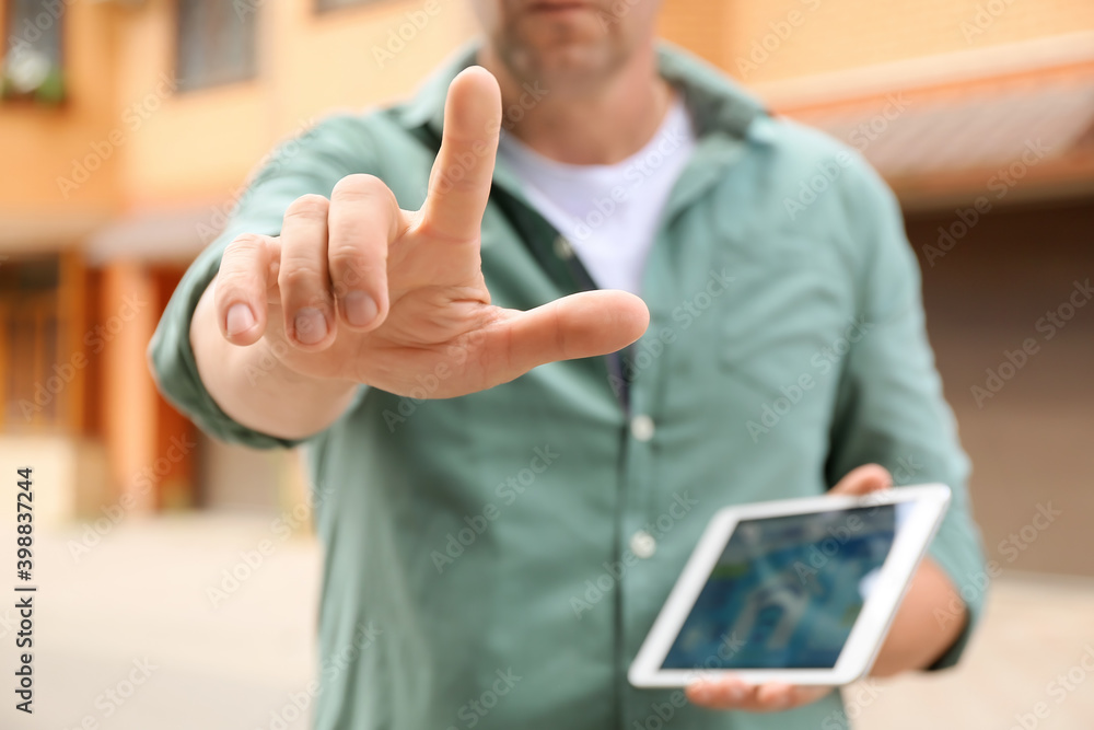 Poster man using tablet computer outdoors
