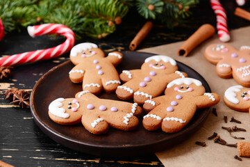 Plate with tasty gingerbread cookies on dark wooden background