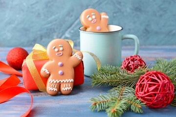 Christmas composition with gingerbread cookies and gift on color background