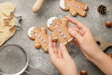 Woman holding Christmas cookie on table