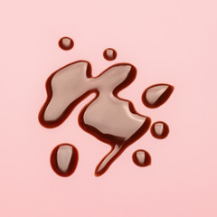 Spilled liquid chocolate on color background