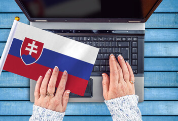 woman hands and flag of Slovakia on computer, laptop keyboard 
