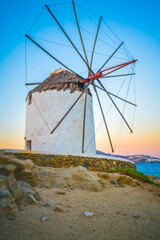 Traditional white windmill near the sea coast at sunrise