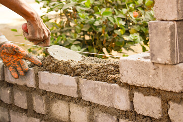 Man laying fly ash bricks to build a wall