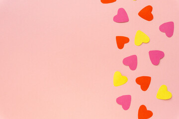 Valentine's day flat lay. Multicolored paper hearts on pink background, space for text