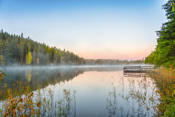 Beautiful lake at sunrise with morning fog