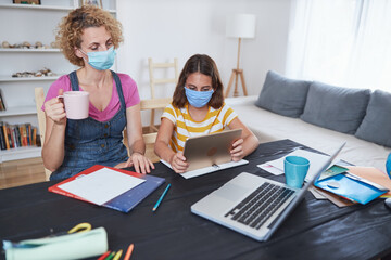 Child home studying education, homeschooling, with private tutor / mother in the time of viruses, flu and seasonal pandemic.