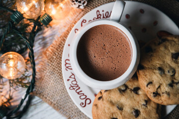 Top view of chocolate mug with Christmas lights chip cookies - Christmas eve - Christmas content - Christmas traditions