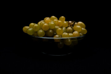 Ripe grapes in glass bowl on dark background