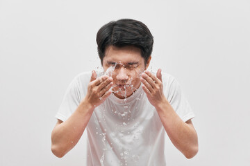 Handsome man is washing up, splash of water, on white background