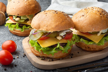 Three burgers. Burgers on a wooden Board. Still life with burgers.