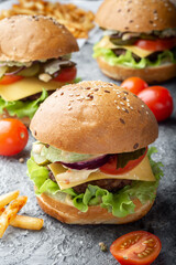 Burgers with French fries. Vertical photo of burgers. Three burgers with French fries.