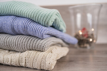 Obraz na płótnie Canvas a stack of warm cozy woolen sweaters jersey jumpers for the winter