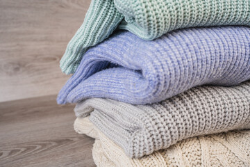 a stack of warm cozy woolen sweaters jersey jumpers for the winter