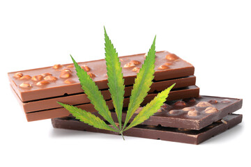 Two bars of black and three milk chocolate and a green hemp leaf on a white isolated background. Chocolate with marijuana extract. Entertainment drug concept
