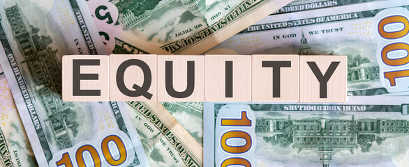 Concept words EQUITY on wooden blocks on a beautiful background from dollar bills.