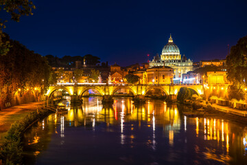 Fototapeta na wymiar Sant' Angelo Bridge and St. Peter's cathedral at night in Vatican City, Rome.Italy