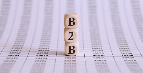 Three wooden cubes with letters B2B , on chart, business