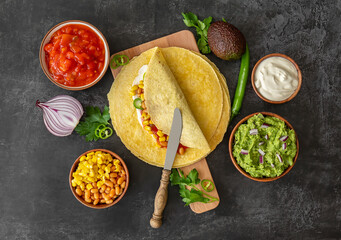 Tortilla wrap or burrito with corn, beans, greens, and homemade guacamole.