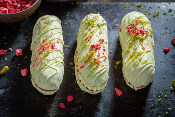 Homemade eclairs with dry pistachios and strawberries