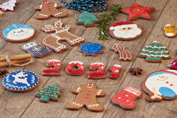 Fototapeta na wymiar Painted Christmas gingerbread cookies on a wooden table. Gingerbread numbers 2021