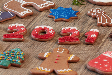 Painted Christmas gingerbread cookies on a wooden table. Gingerbread numbers 2021
