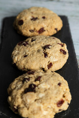 Homemade oatmeal and blueberry cookies on white wood - healthy food and snacks