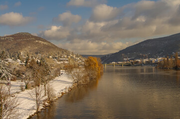 Winter with snow in old downtown, castle and main city bridge in Heidelberg, Germany, with blue cloudy sky and sunny day.