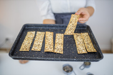 Female hand holding a black tray of Swedish crispbread