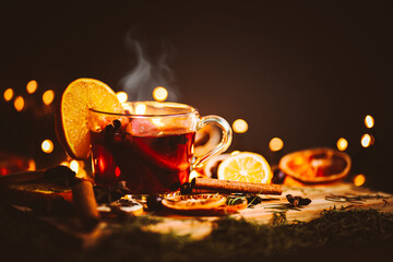 Christmas mulled wine, Drink with dried fruits and berries, Winter hot tea in a glass and spices on a wooden background.	 - obrazy, fototapety, plakaty