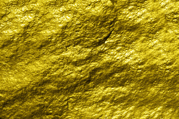 Fragment of a wall from a chipped golden stone background 