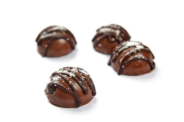 Round sweets with milk chocolate on a white background