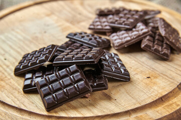 Bars of black and milk chocolate on a wooden tray