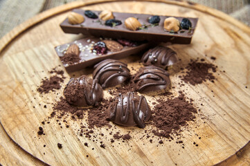 Milk chocolate with nuts and dried fruits on a wooden tray
