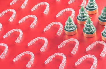 Muchos Alineadores dentales invisibles o alineadores transparentes sobre fondo rojo para navidad. Tratamiento de ortodoncia estético que hace el dentista en la clínica dental.