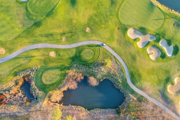Above view of a green field next to an autumn forest