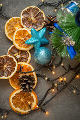 Dried orange and lemon slices in Christmas composition on dark background. Top view, selective focus
