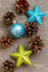 Ball and stars for Christmas tree on dark concrete background. New Year's card with pine cones. Selective focus, close-up