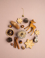 Christmas ball ornament shape arrangement made with reindeer, cinnamon rolls and gingerbread man on neutral color palette background. Minimal New year celebration concept. Flat lay, top view.