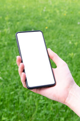 Person's hand holding smartphone with blank white screen mock up on green background, business 