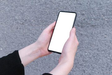 Person's hand holding smartphone with blank white screen mock up on grey background, business 