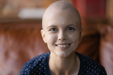 Head shot portrait smiling hairless woman cancer patient posing, looking at camera, overjoyed cancer patient struggling with oncology disease, successful treatment results, remission and recovery