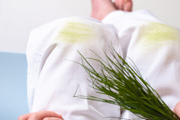 Child's hand holding the grass. dirty grass stains on children's pants. daily life dirty stain for wash and clean concept