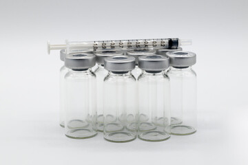 Six medical Vaccine ampules one syringe Sitting  on a white background