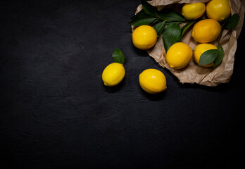 Fresh lemons on dark stone background. Top view.