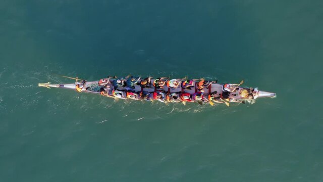Dragon Boat team rowing to the pace of an onboard Drummer, Aerial view.

