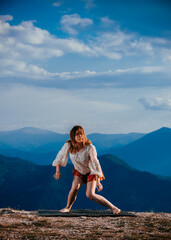 Portrait of a fit, young hip hop dancer while dancing in red skirt on mountain