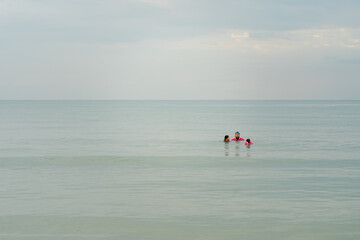 Fototapeta na wymiar Family swimming in sea in the morning.