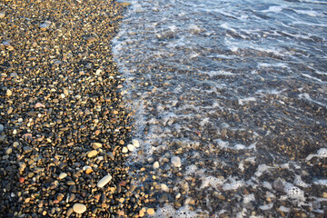 waves of the sea roll on the stone beach
